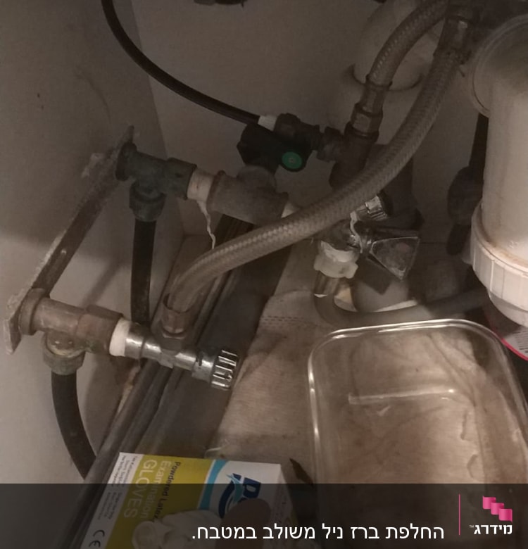 צינורות מים וברזים מתחת לכיור מטבח